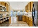 Traditional kitchen featuring wooden cabinetry, stainless steel appliances, tile flooring, and breakfast nook at 26148 Glen Eagle Dr, Leesburg, FL 34748