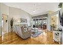 Bright living room with hardwood floors, vaulted ceilings, a ceiling fan, and sliding glass doors at 26148 Glen Eagle Dr, Leesburg, FL 34748