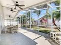 Spacious screened lanai with patio furniture, ceiling fans and tropical landscaped backyard at 2917 White Cedar Cir, Kissimmee, FL 34741