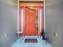 Inviting front entrance showcasing a vibrant orange door and charming outdoor decor at 320 Bentwood Dr, Leesburg, FL 34748