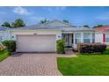Inviting single-story home with a two-car garage, brick driveway and well-maintained landscaping at 32708 Westwood Loop, Leesburg, FL 34748