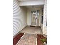 Covered front entrance featuring a tiled porch and brick walkway at 32708 Westwood Loop, Leesburg, FL 34748