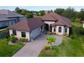 Beautiful home featuring an attached two car garage, brick paver driveway, and lush landscaping at 5413 Sandy Hill Ln, Lady Lake, FL 32159