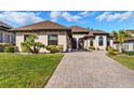 Lovely single story home features beautiful landscaping, a water feature, and a brick paver driveway at 5413 Sandy Hill Ln, Lady Lake, FL 32159