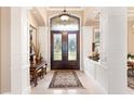 Grand foyer with a decorative glass double door, high ceilings, columns, and travertine floors at 631 Old Mount Dora Rd, Eustis, FL 32726