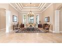 Spacious living room with tray ceiling, travertine floors, large windows, and classic decor at 631 Old Mount Dora Rd, Eustis, FL 32726