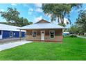 Inviting home with a metal roof, covered porch, and lush green lawn at 654 Nw 9Th Ave, Webster, FL 33597