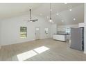 Bright, open-concept living space featuring wood-look floors, vaulted ceilings, and modern lighting at 654 Nw 9Th Ave, Webster, FL 33597