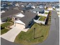 Lovely aerial view of a home in a neighborhood with lush green lawns and mature trees at 6576 Merrill Ln, The Villages, FL 34762