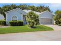 Inviting home with a paver driveway and a lush, green front yard at 726 Grand Vista Trl, Leesburg, FL 34748