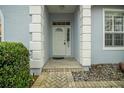 Inviting front entryway with decorative columns and a well-maintained paver walkway at 726 Grand Vista Trl, Leesburg, FL 34748