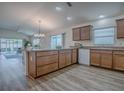 Open kitchen with a center island, wood cabinets, and stainless steel appliances that opens to the dining area at 796 Elliott Ave, The Villages, FL 32163