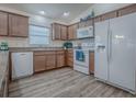 Bright kitchen featuring wood cabinets, white appliances, and modern finishes with durable flooring at 796 Elliott Ave, The Villages, FL 32163