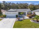 Lovely single-story home featuring a manicured lawn, a two-car garage, and a beautifully landscaped front yard at 8373 Se 177Th Bartram Loop, The Villages, FL 32162