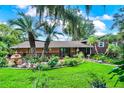 Charming single-Gathering home featuring lush landscaping, a decorative fountain, and mature palm trees at 840 2Nd St, Clermont, FL 34711