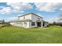 Spacious backyard with lush green grass, black metal fencing, and covered patio, perfect for entertaining at 977 Timberview Rd, Clermont, FL 34715