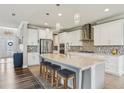 Gourmet kitchen with white cabinetry, stainless steel appliances, large center island and pendant lighting at 977 Timberview Rd, Clermont, FL 34715