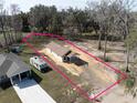 Aerial view of a newly built single-story home with a spacious lot outlined in pink at Lot 15 Indian Estates Cr 423, Lake Panasoffkee, FL 33538