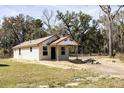 Newly constructed single-story home with board siding and a small covered porch at Lot 15 Indian Estates Cr 423, Lake Panasoffkee, FL 33538