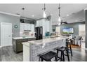 Open concept kitchen featuring granite countertops, modern cabinetry, and stainless steel appliances at 11101 Versailles Blvd, Clermont, FL 34711