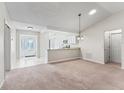 Open-concept living area with neutral walls, carpet flooring, and views into the adjacent kitchen at 1303 Fontana Ct, Lady Lake, FL 32159