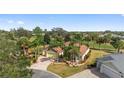 Aerial view of a beautiful home, with a three car garage, palm trees, mature landscaping and paver driveway at 1312 Patrick Pl, The Villages, FL 32162