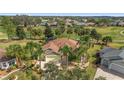 Stunning aerial view of a residence featuring manicured lawns, a screened lanai, and verdant golf course surroundings at 1312 Patrick Pl, The Villages, FL 32162