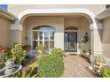 Inviting front porch with brick flooring, decorative plants, and a cozy seating area next to the front door at 1339 Florence Path, The Villages, FL 32162