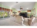 Bright living room featuring plush carpeting, a ceiling fan, and sliding glass doors to the outdoors at 1339 Florence Path, The Villages, FL 32162