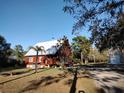 Inviting log cabin showcasing a well-maintained lawn and a detached garage, creating a serene setting at 14415 County Road 448, Tavares, FL 32778