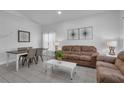 Bright living room with tile flooring, a comfortable brown sofa set, and tastefully decorated with modern art and soft lighting at 16726 Hidden Spring Dr, Clermont, FL 34714