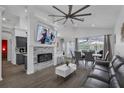 Bright living room featuring a stone fireplace, high ceilings, and views of the pool through large windows at 16739 Hidden Spring Dr, Clermont, FL 34714