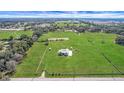 Expansive aerial view of a sprawling property with a modern home surrounded by lush greenery and mature trees at 1679 E County Road 462, Wildwood, FL 34785