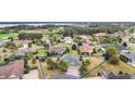 Aerial view of a home highlighting its location in a serene neighborhood near a golf course and lake at 2059 Landings Ln, The Villages, FL 32162