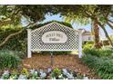 Holly Hill Villas sign framed by lush greenery and colorful flowers, welcoming residents and visitors at 2495 Birch Ave, The Villages, FL 32162