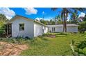 White exterior of home showing the side and back with a brick patio area and green lawn at 2610 Stephens Rd, Groveland, FL 34736