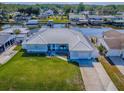 Waterfront single-story home with a metal roof, green lawn and a boat dock and lift on a canal at 26608 E Cove Dr, Tavares, FL 32778