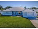 Charming single-story home with a metal roof, blue siding, and a well-maintained lawn at 26608 E Cove Dr, Tavares, FL 32778