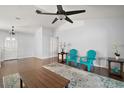 Spacious living room with wood floors, ceiling fan, and two blue chairs at 26608 E Cove Dr, Tavares, FL 32778