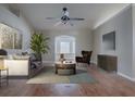 Bright and airy living room with hardwood floors, modern furniture, ceiling fan and an arched doorway at 26608 E Cove Dr, Tavares, FL 32778