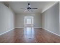 Spacious living room features hard wood floors, ceiling fan and an arched doorway at 26608 E Cove Dr, Tavares, FL 32778