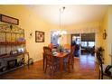 Cozy dining room with hardwood floors, a chandelier, and a view of the outdoor lanai at 2682 Edwards Ln, The Villages, FL 32162