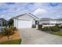 Charming single-story home featuring a well-maintained lawn, mature shrubbery, and a two car garage at 3780 Viscaya Ct, The Villages, FL 32163