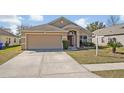 Inviting home exterior featuring a well-maintained lawn, and a neutral color palette at 4078 Waltham Forest Dr, Tavares, FL 32778