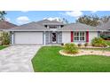 Charming single-story home with a well-manicured lawn and a two-car garage at 4609 Inverness Dr, Leesburg, FL 34748