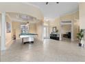 Expansive living room with tile flooring, pool table, and decorative columns at 4955 Ne 124Th Rd, Oxford, FL 34484