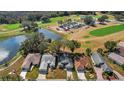 Aerial view showcasing the home near a scenic pond and a beautiful golf course at 544 Grand Vista Trl, Leesburg, FL 34748