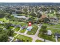 Aerial view of home in a quiet community near a pond, amenities, and lush landscaping at 701 Brigadoon Cir, Leesburg, FL 34788