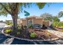 Street view of landscaped corner lot with bench, mature trees, and walkway to the house at 922 Cancun Ct, The Villages, FL 32159