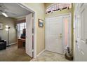 Welcoming foyer featuring tile flooring, decorative window, and direct access to a sunny home office space at 932 Medira Dr, The Villages, FL 32159